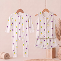 A baby bamboo sleepsuit and jabla shorts set  displayed on wooden hangers against a soft beige background. The set includes a long-sleeve footless one-piece pajama with a front zipper and matching sleeveless top and shorts.