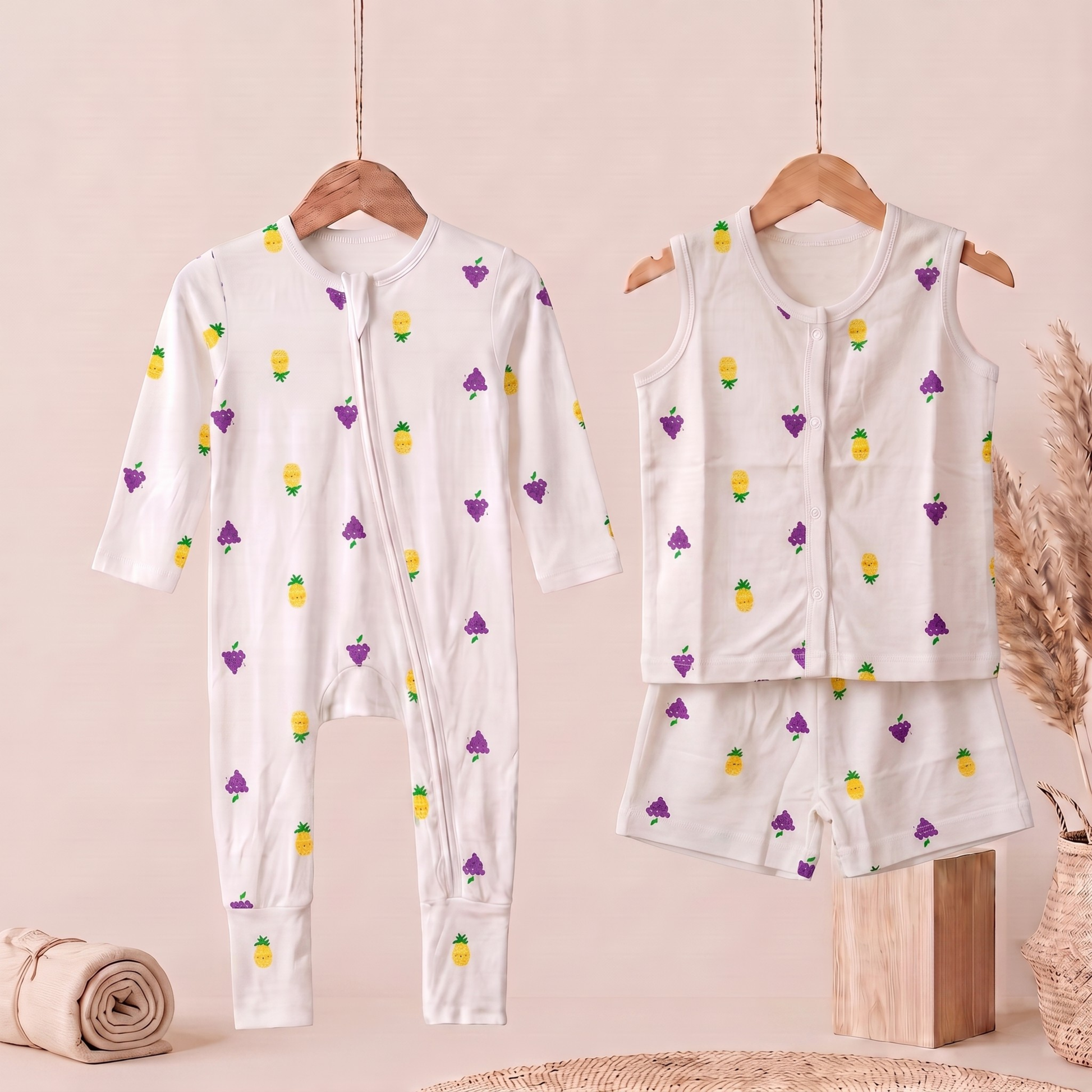 A baby bamboo sleepsuit and jabla shorts set  displayed on wooden hangers against a soft beige background. The set includes a long-sleeve footless one-piece pajama with a front zipper and matching sleeveless top and shorts.