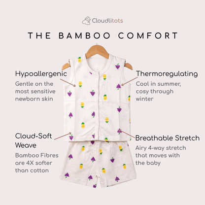 A baby two-piece bamboo jabla and shorts set from Cloudlitots, featuring a white sleeveless vest and matching shorts with a small yellow pineapple and purple grape pattern. The image includes text callouts highlighting key features like hypoallergenic, thermoregulating, soft weave, and stretchable bamboo fibers.