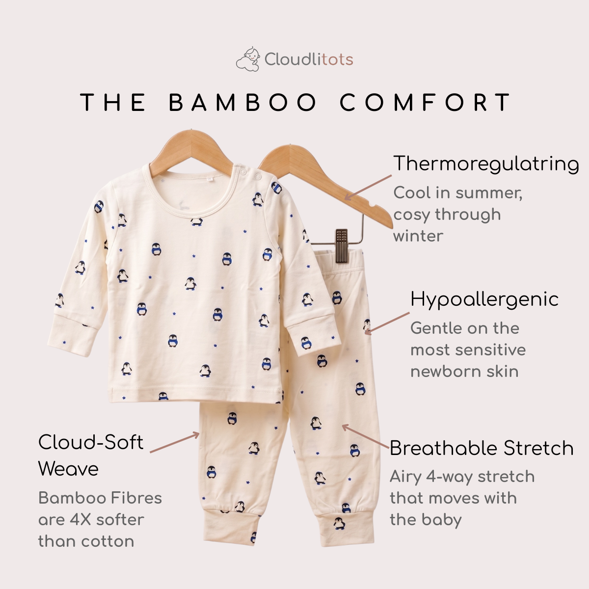 A two-piece baby bamboo lounge set displayed on wooden hangers against a light beige background, with text callouts highlighting features such as thermoregulating fabric, hypoallergenic softness, breathable stretch, and Cloud-Soft Weave. The set is cream-colored with a small blue penguin print.